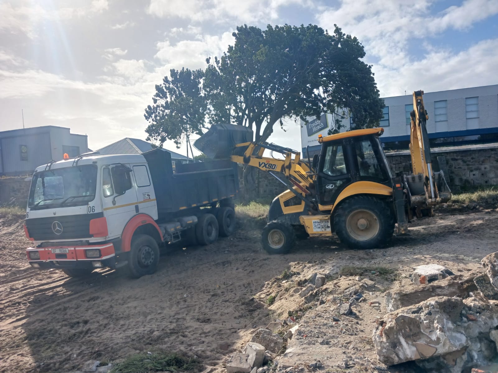 Excavator loading trucks