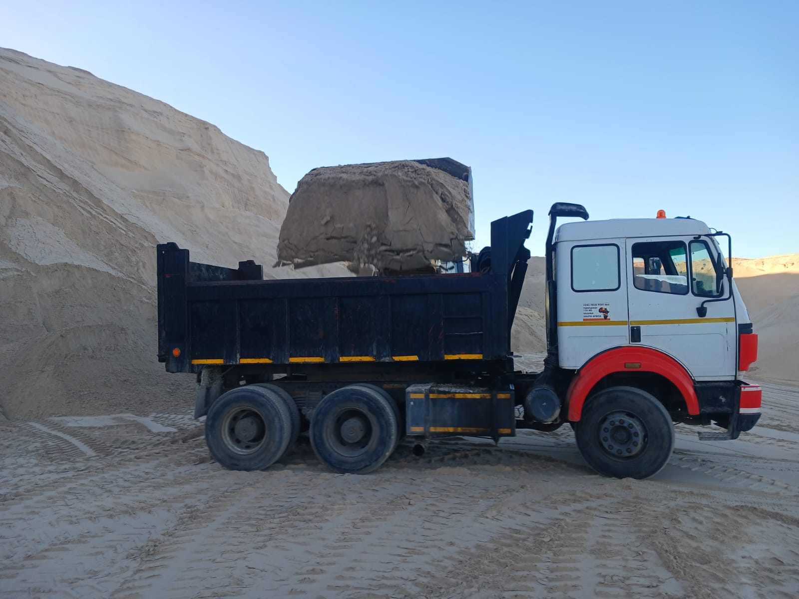 Tipper truck delivering sand